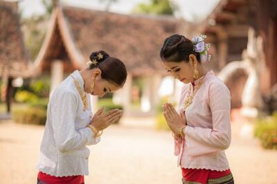 Wai Greeting. Thailand. Two Thai women in Sawasdee action.